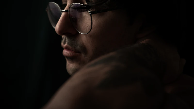 a man with glasses and no shirt on