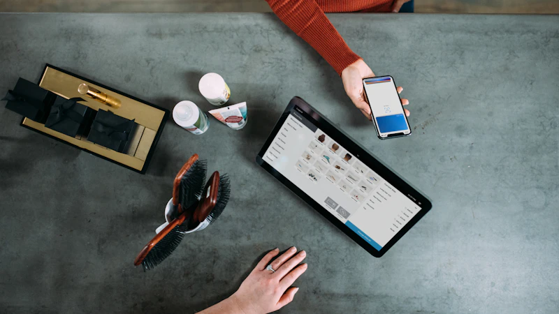 person holding smartphone beside tablet computer