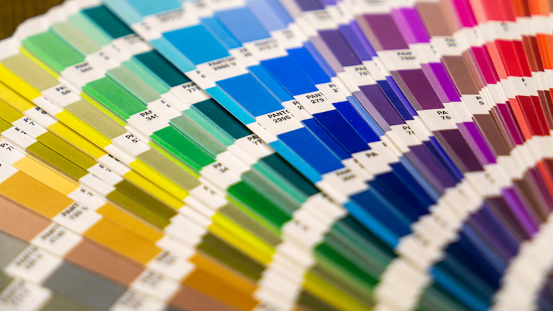 A fan deck of colorful paper swatches arranged in a spectrum on a surface