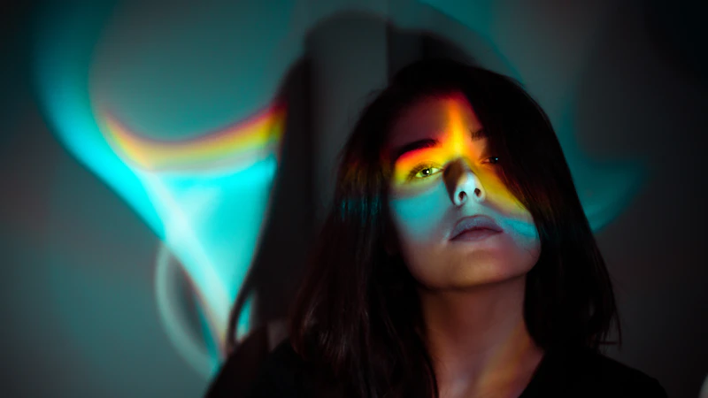a woman with a rainbow painted face in a dark room