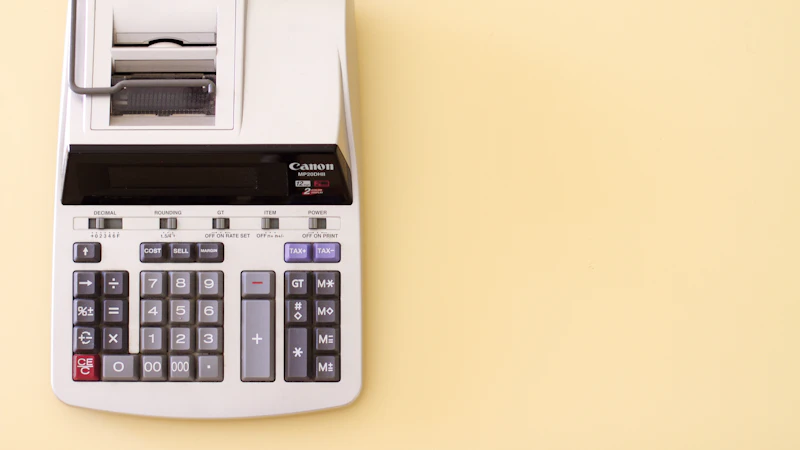 A grey printing calculator on a light yellow background