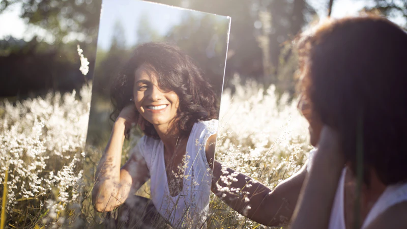 woman in blue and white floral shirt holding her face