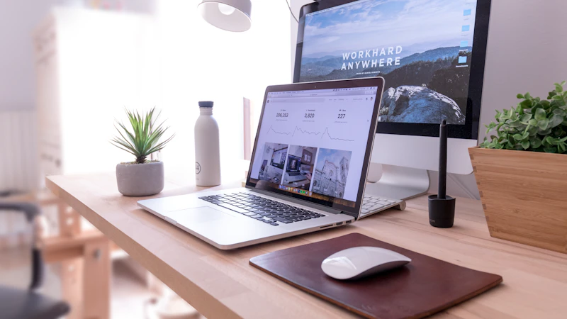 MacBook Pro on table beside white iMac and Magic Mouse