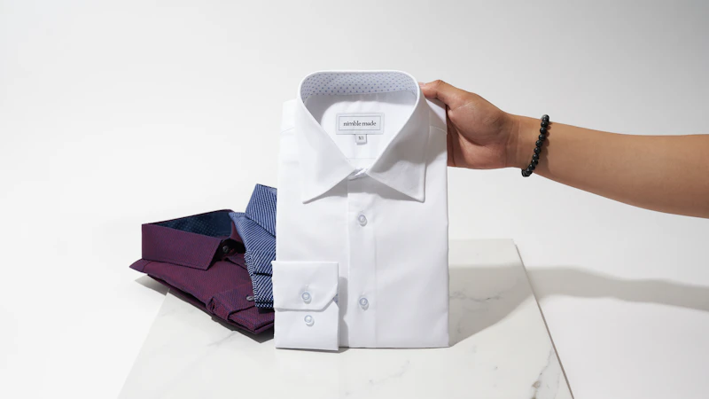 person holding white button up shirt