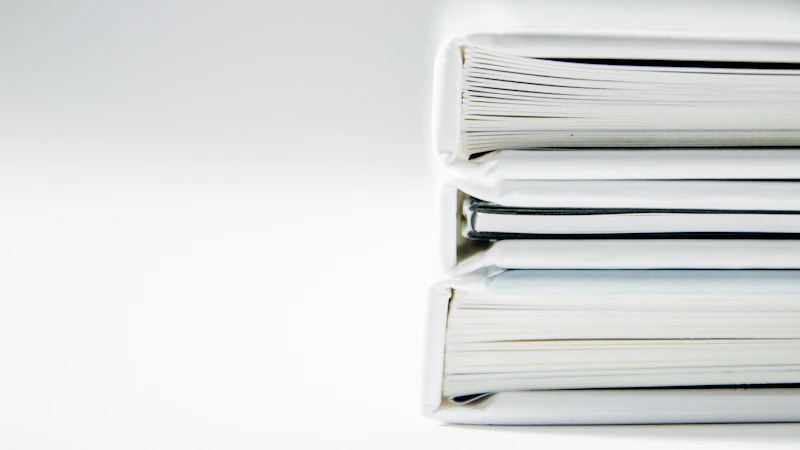 A stack of thick folders on a white surface
