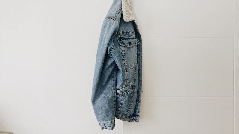 blue washed jacket hanging on white door
