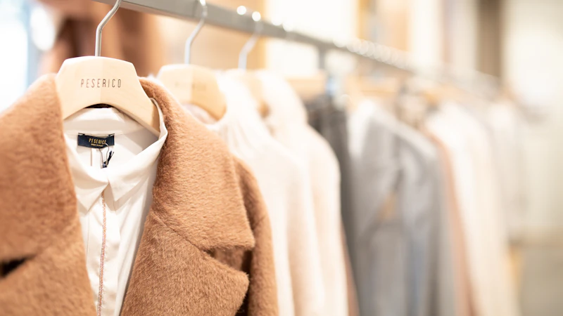 brown coat hanged on white plastic hanger