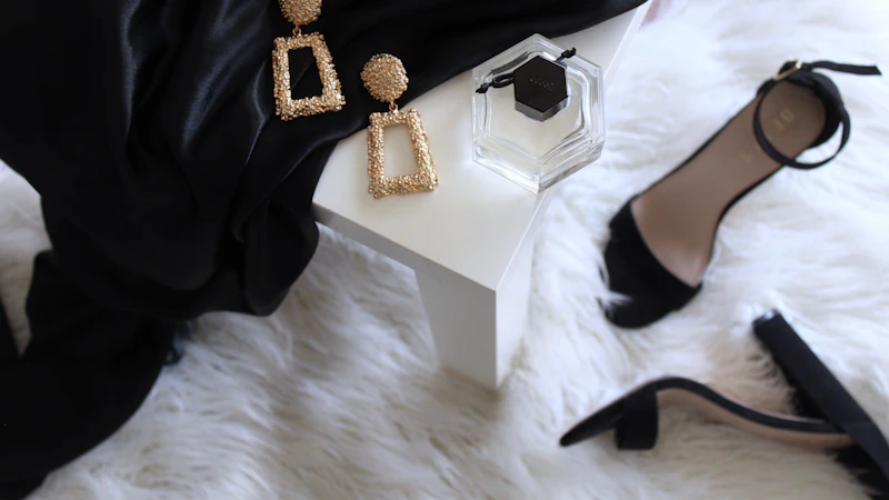 pair of gold-colored earrings on table and black ankle-strap pumps on area rug