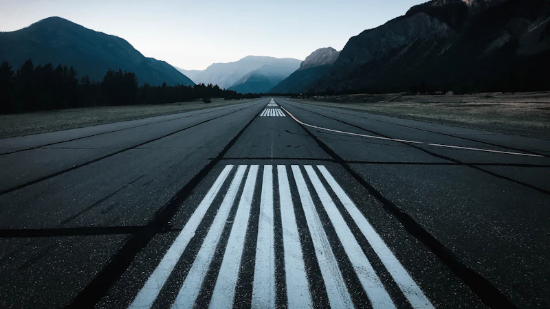 an empty runway with mountains in the background