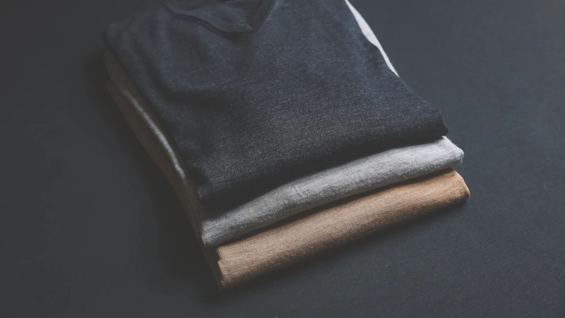 three black,grey,and brown V-neck shirt on black surface