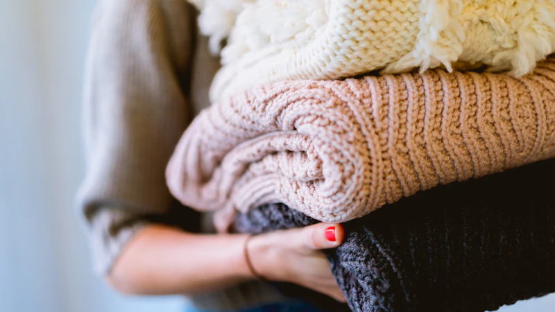 person holding knitted textiles