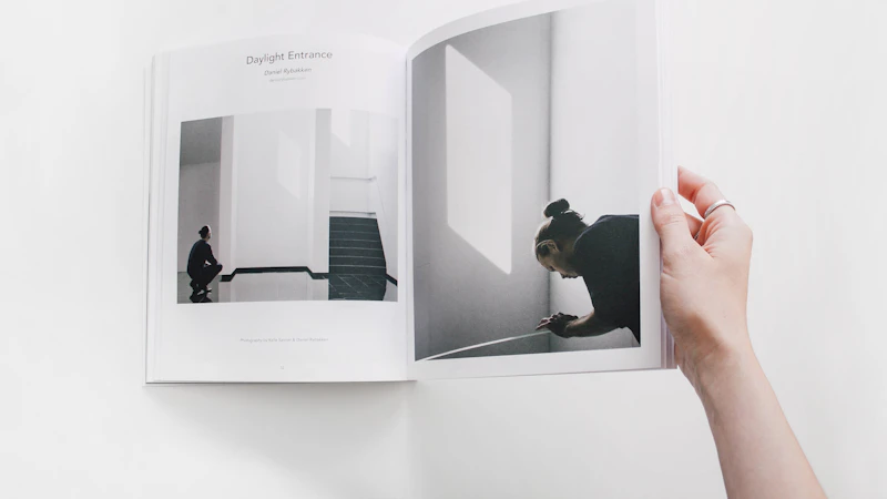 person reading book on white surface