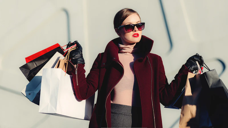 photo of woman holding white and black paper bags