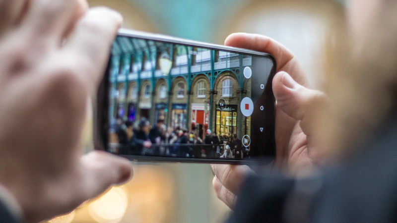 person holding smartphone taking video of people