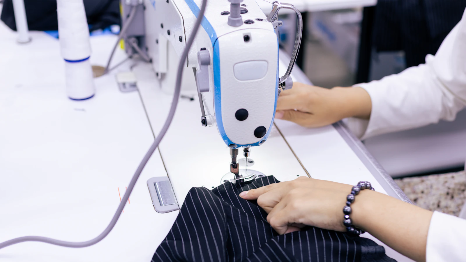 a woman using a sewing machine to sew clothes