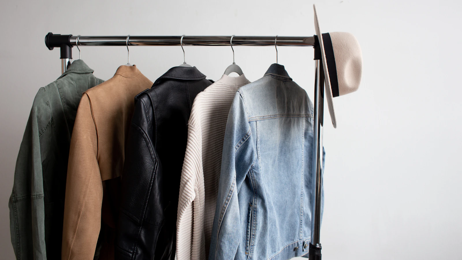 one cowboy hat and five jackets hanged on clothes rack