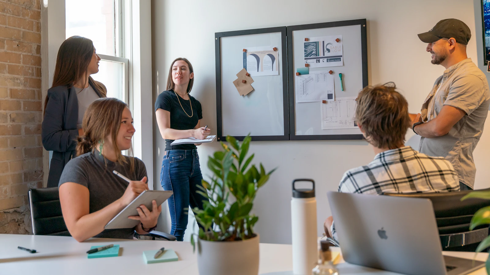 A group of people in a sunlit office during a collaborative workspace meeting