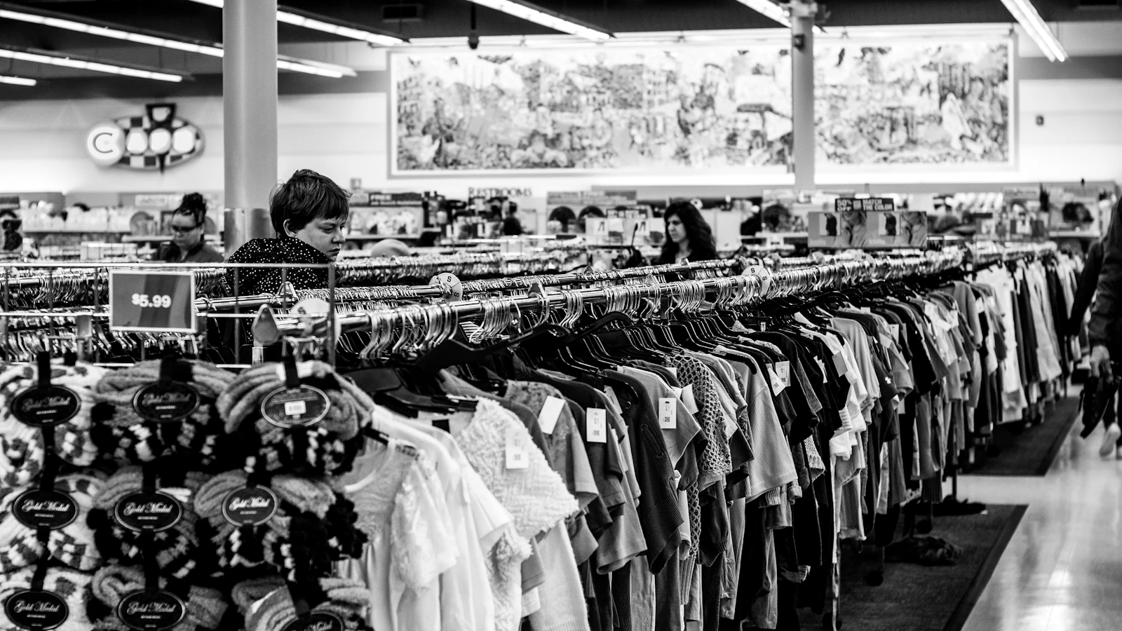 grayscale photography of people inside a clothing shop