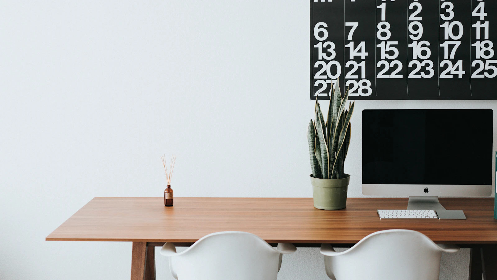 silver iMac on brown wooden desk