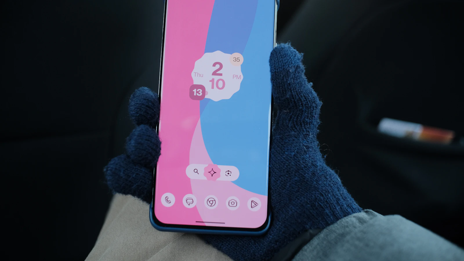 Hand holding a smartphone with a colorful wallpaper