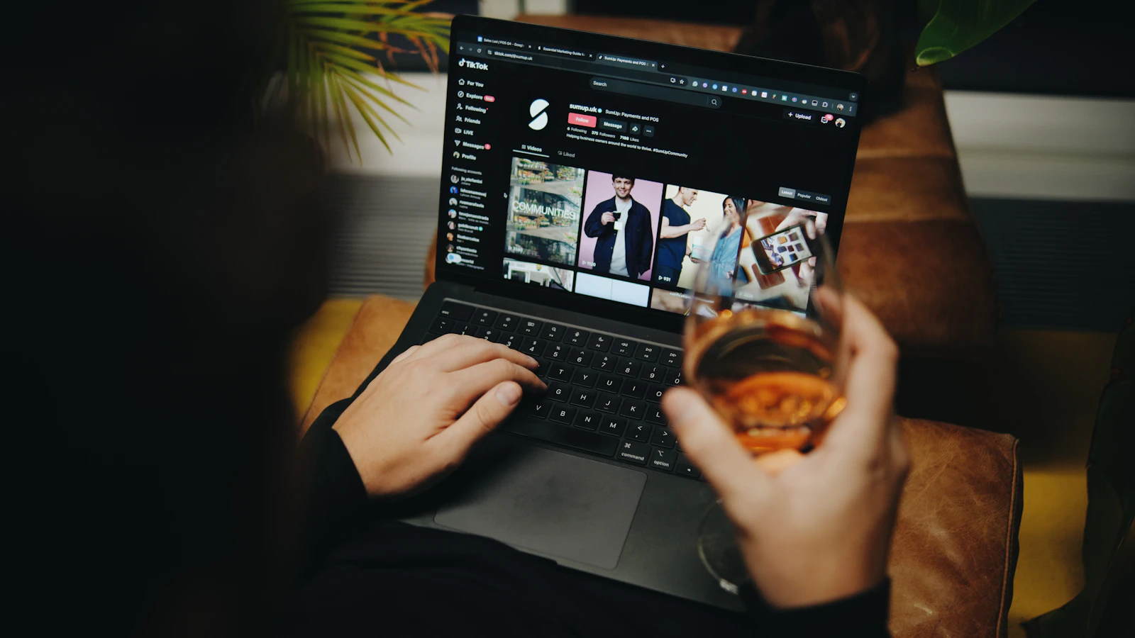 A person sitting on a couch with a laptop