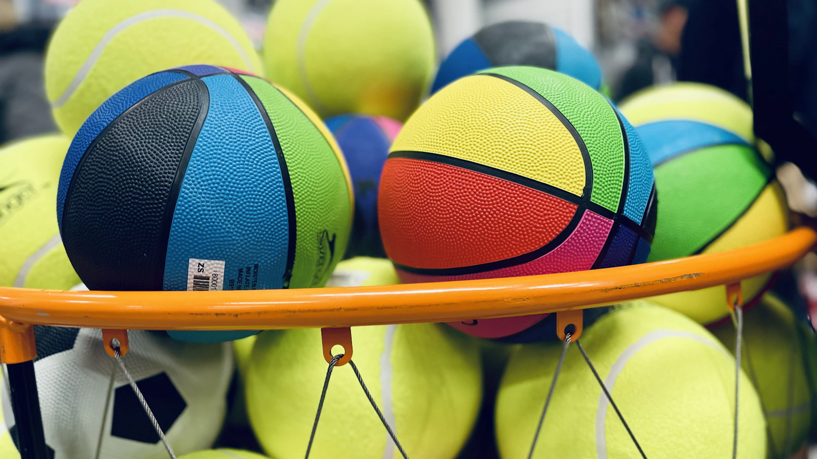 a pile of tennis balls sitting on top of a rack