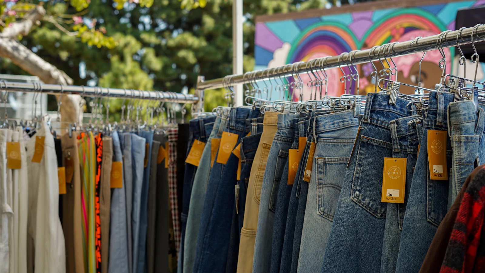 a rack of jeans hanging on a clothes line