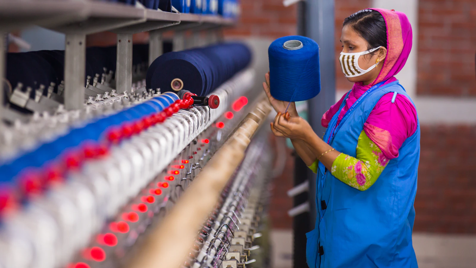 Woman working with blue yarn on a machine
