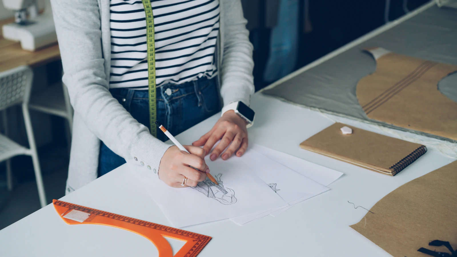 A fashion designer is sketching designs on paper