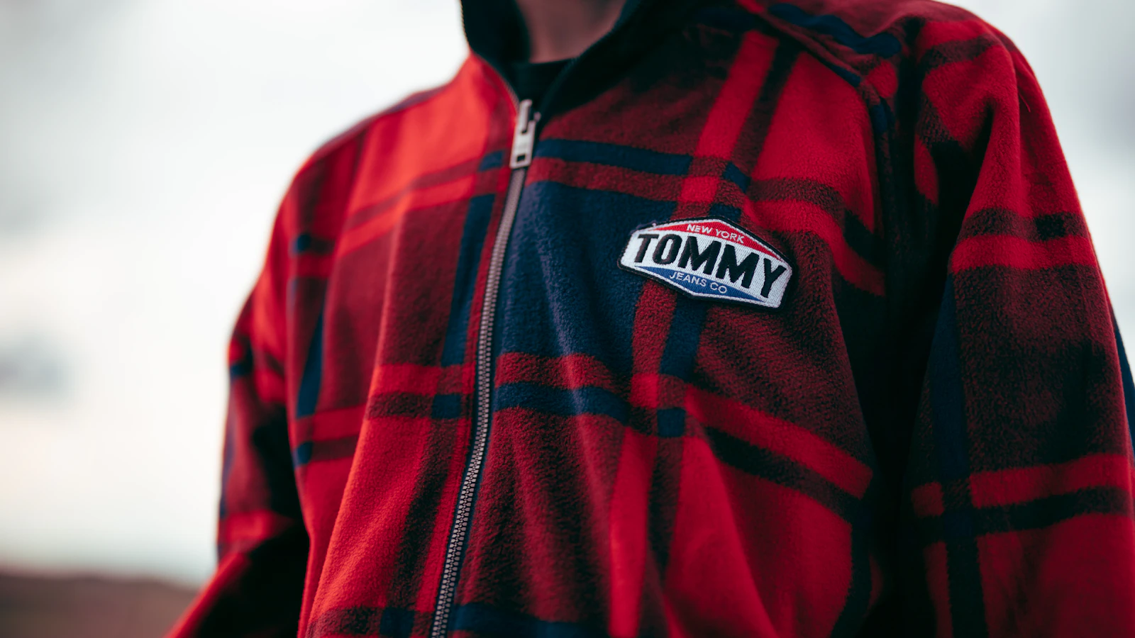 man in red and black adidas zip up jacket
