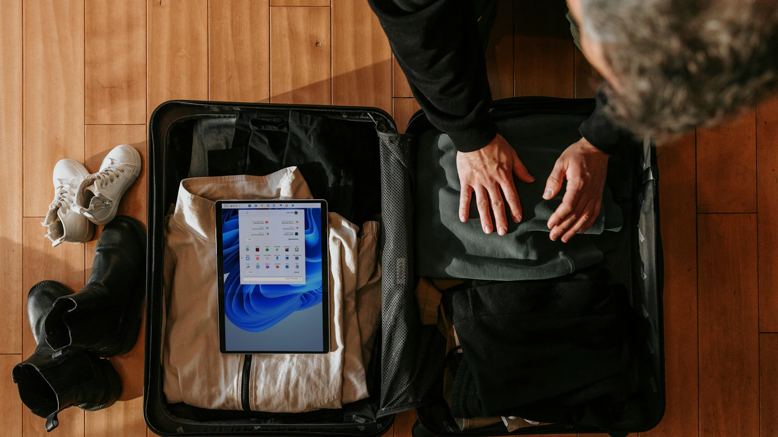 an overhead view of a person packing a suitcase