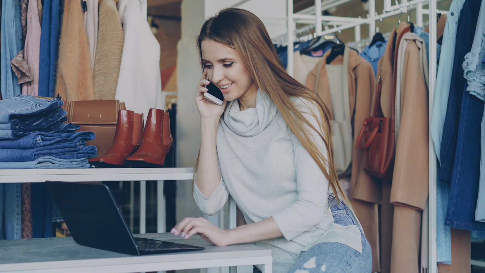 Woman talks on the phone while using a laptop