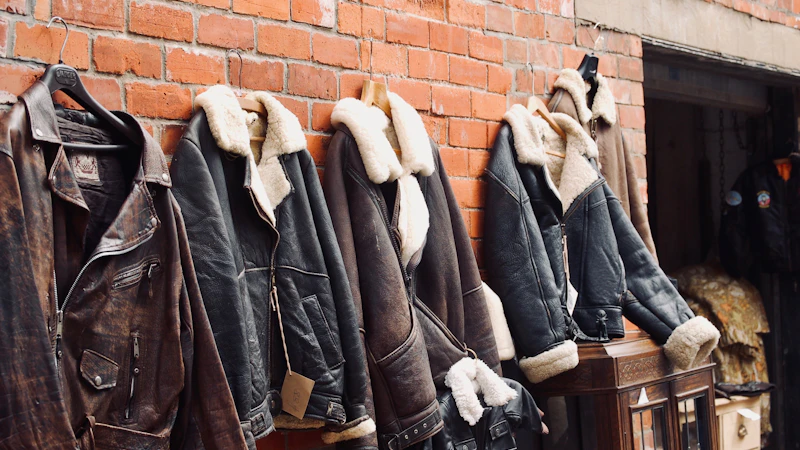 four assorted leather jackets hanging on brown brick wall
