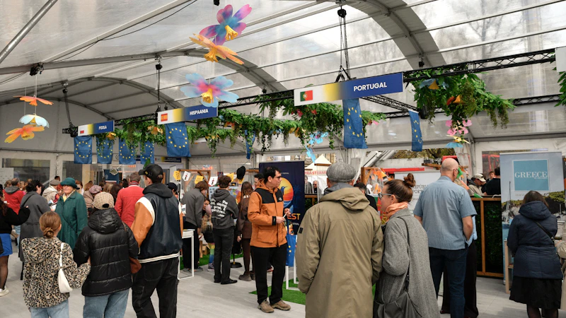Crowd gathered inside a large tent with decorated stalls