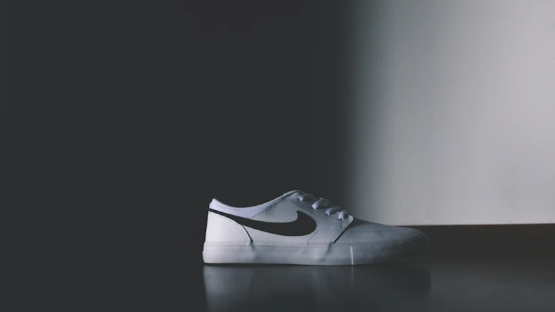 unpaired white Nike low-top shoe